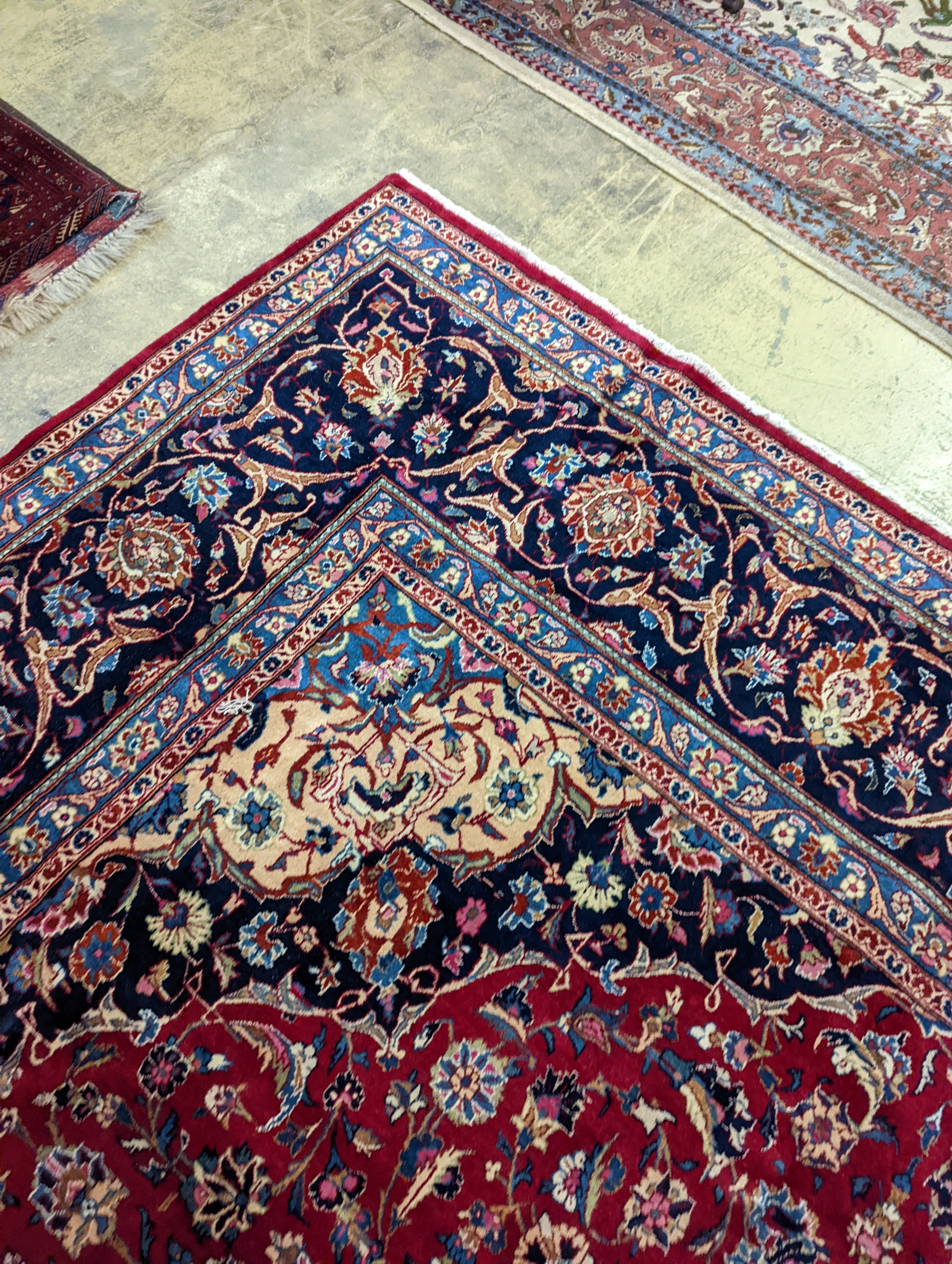 A Kashan burgundy ground carpet, 380 x 300cm